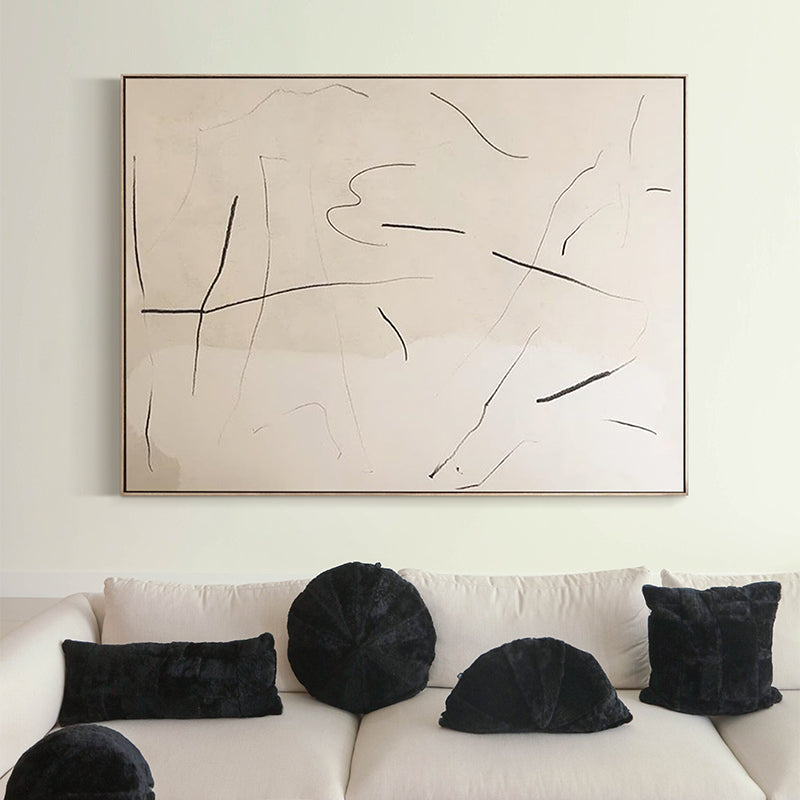 Minimalist black and beige abstract painting above a modern sofa